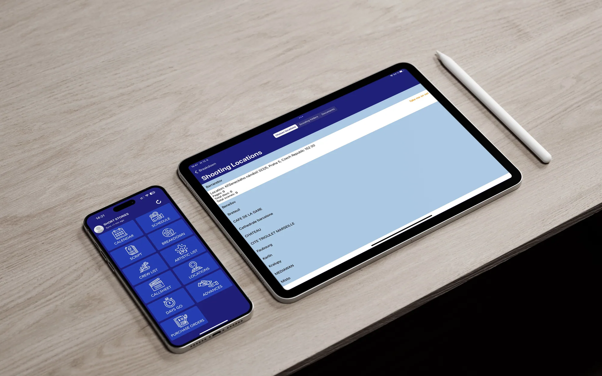Telefon a tablet vedle sebe na světlém dřevěném stole s Apple Pencilem: na telefonu nabídka nástrojů aplikace, na tabletu seznam natáčecích lokací.